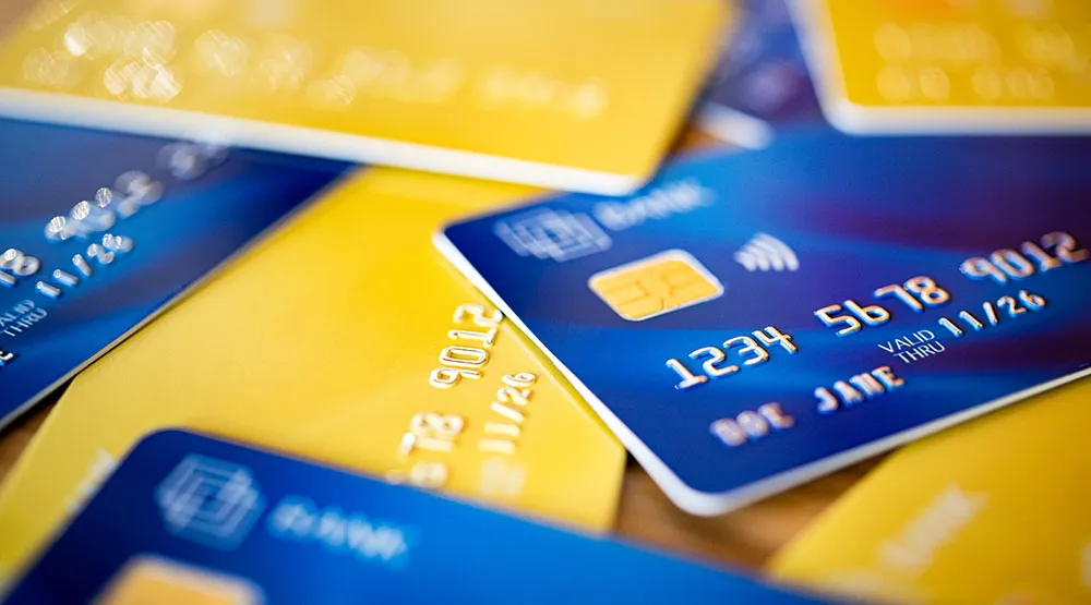 A pile of assorted bank cards in blue and yellow to illustrate the report